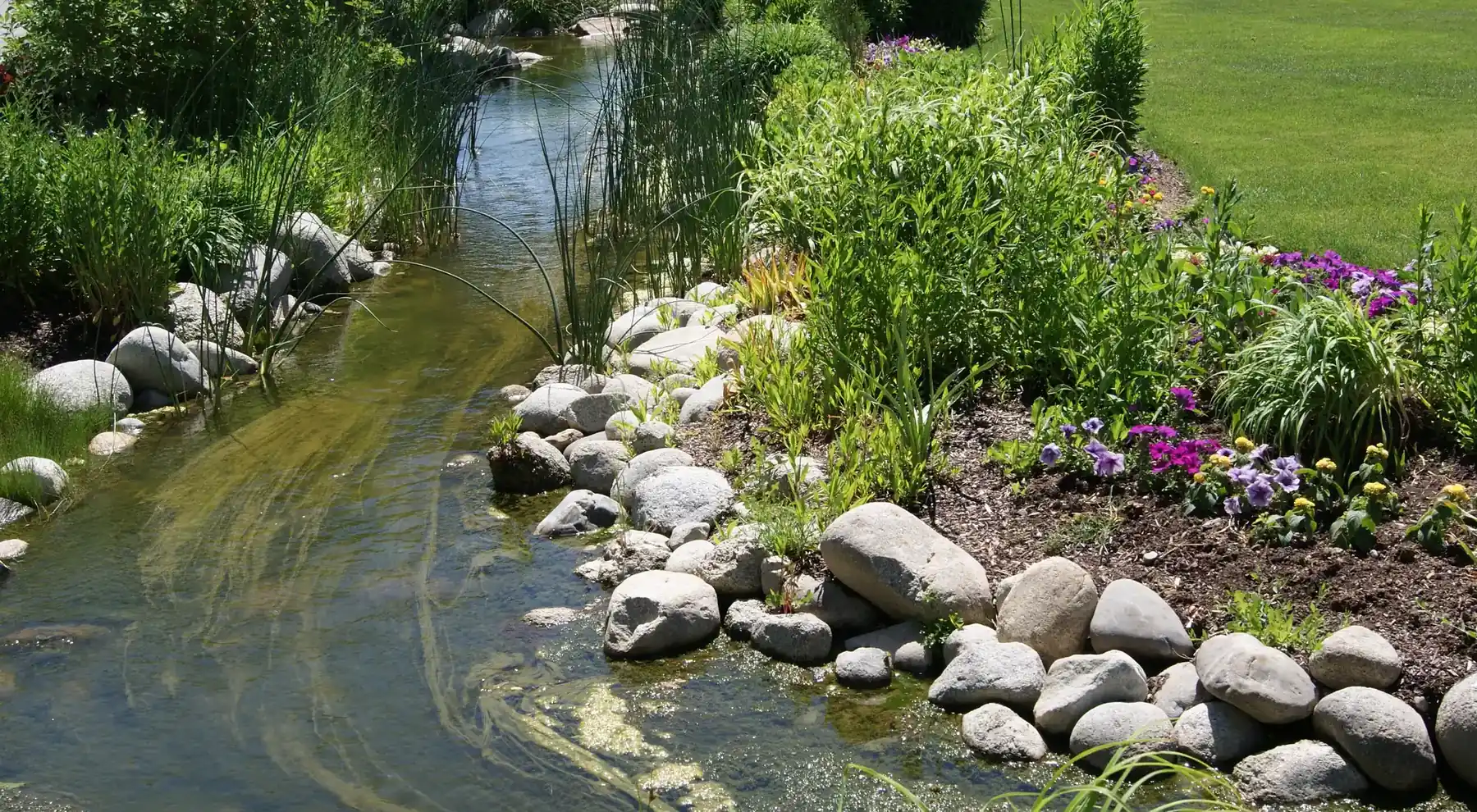 A rock-lined stream and flower beds at Ashton Gardens, Thanksgiving Point, Lehi